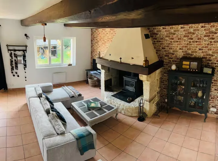 Spacieux salon avec poêle à bois scandinave et babyfoot du gîte La Grange